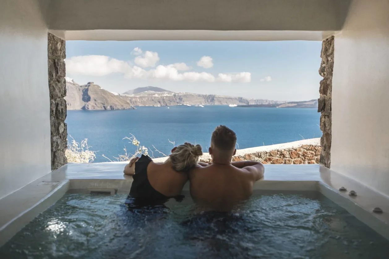 Couple enjoying view from Mystique A Luxury Collection Hotel Santorini
